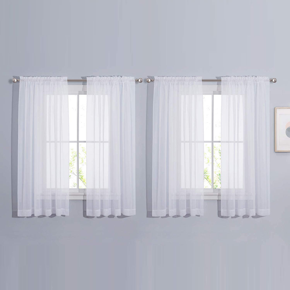 Four white sheer voile rod pocket curtains, hanging on two windows, providing privacy for living room or bedroom.