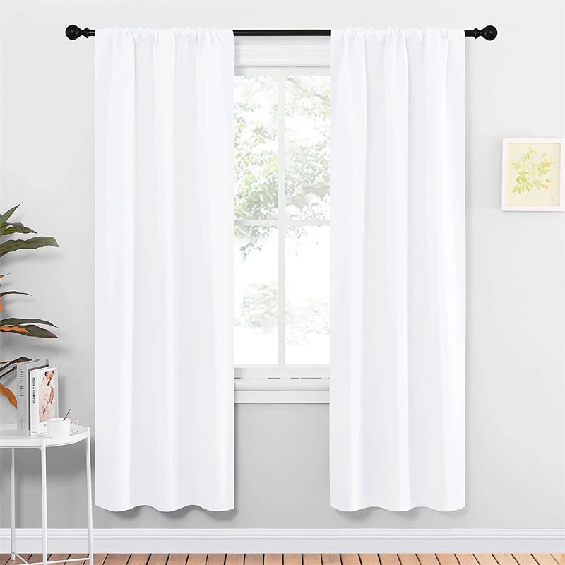 White rod pocket thermal insulated blackout curtains (2 panels) providing privacy on a window in a modern living room or bedroom.