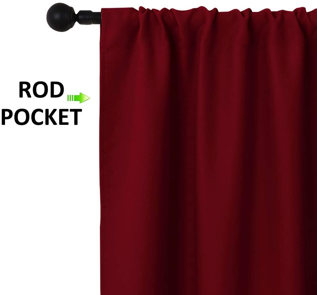 Deep red rod pocket triple weave blackout curtain panel on black rod for living room and bedroom decor.