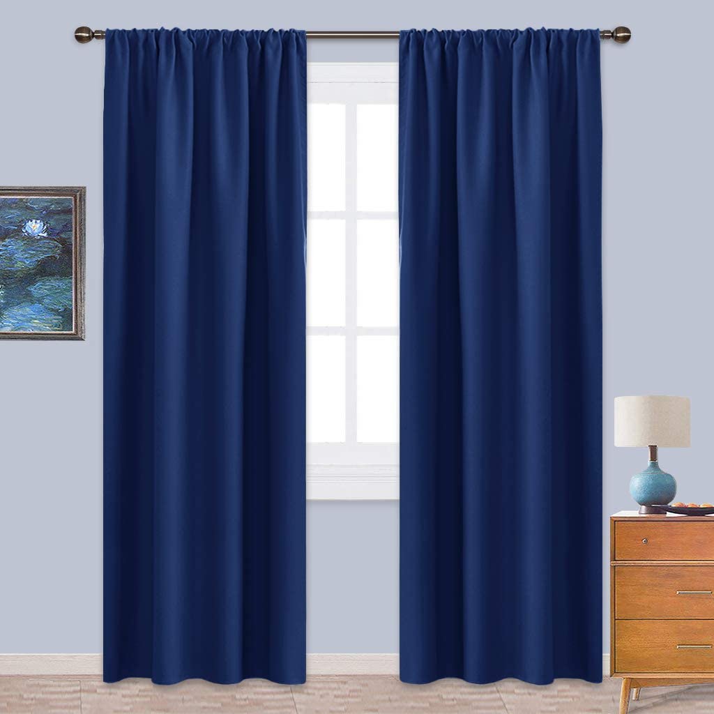 Navy blue rod pocket triple weave blackout curtains, 2 panels, shown in a living room blocking light from a window.