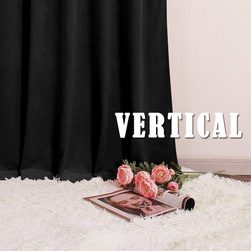 Luxurious black velvet rod pocket curtain panel for noise reducing blackout, drapes to a white fluffy rug with flowers.
