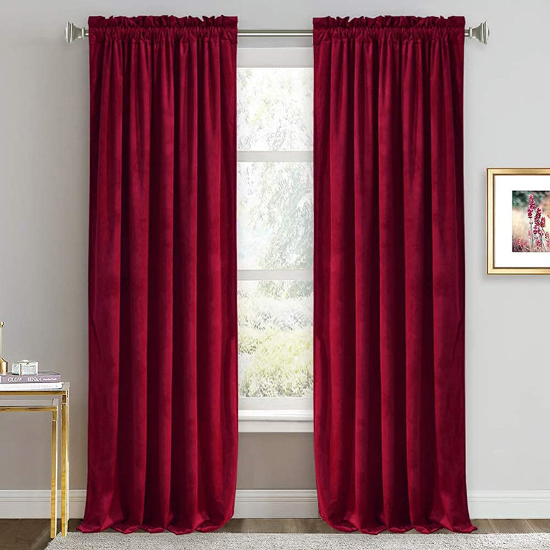 Luxurious pair of deep red velvet rod pocket curtains, offering noise reducing blackout for a living room or bedroom window.