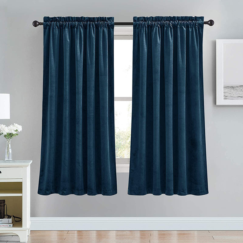 Two dark blue velvet rod pocket blackout curtains in a living room, offering luxury and noise reduction.