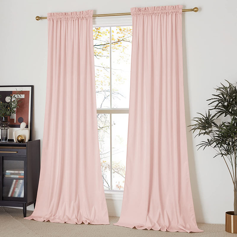 Two blush pink rod pocket velvet blackout curtains covering a window, offering privacy & light control for living room or bedroom.