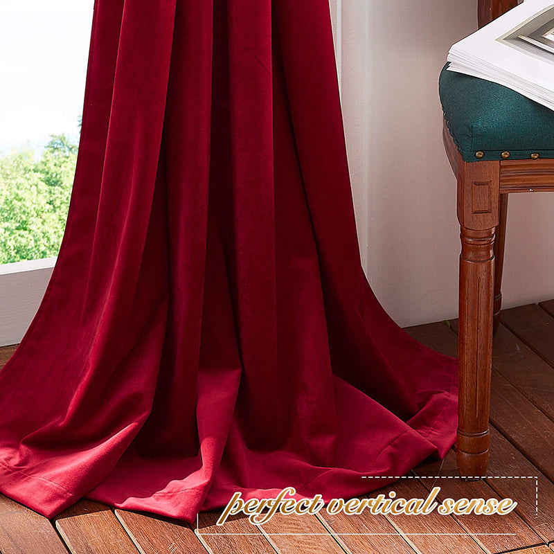 Luxurious red velvet blackout curtains with rod pocket, pooling on a wooden floor, ideal for living room or bedroom privacy.