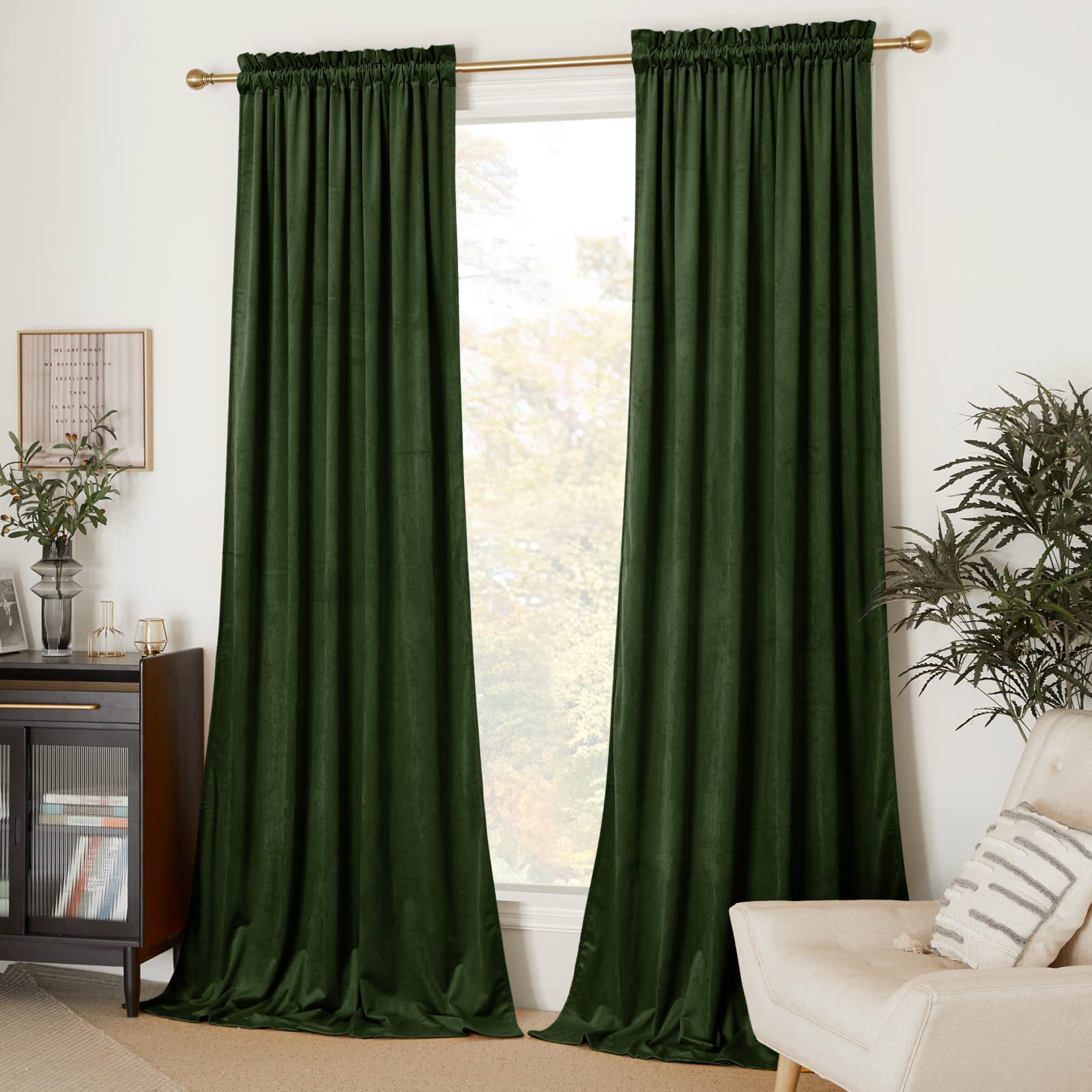 Two dark green velvet rod pocket blackout curtain panels in a living room, providing privacy for a window.