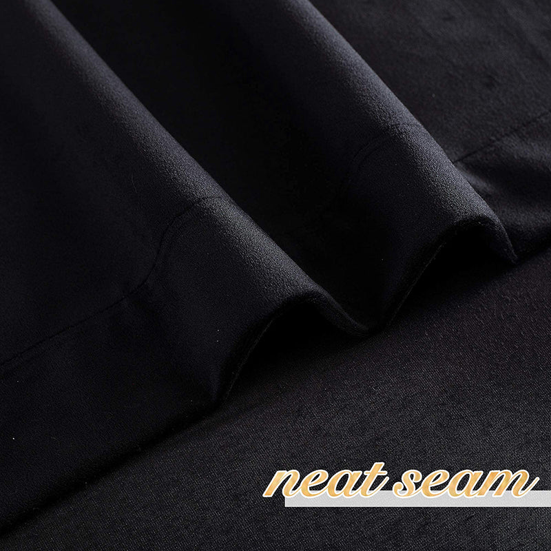 Luxurious black velvet blackout curtain fabric detail, highlighting plush texture and a neat seam for bedroom and living room privacy.