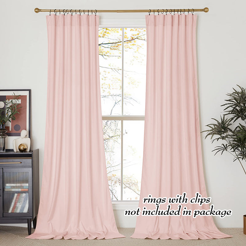 Two panels of blush pink velvet rod pocket blackout curtains hung with rings on a gold rod for living room and bedroom privacy.