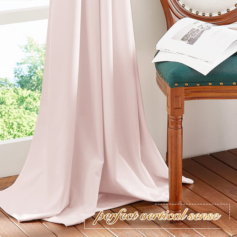 Luxurious blush velvet rod pocket blackout curtain drapes elegantly to the wooden floor by a window, perfect for living room privacy.