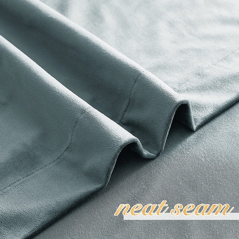Close-up of luxurious teal velvet blackout curtain fabric, showcasing its soft texture and neat seam for superior privacy protection.