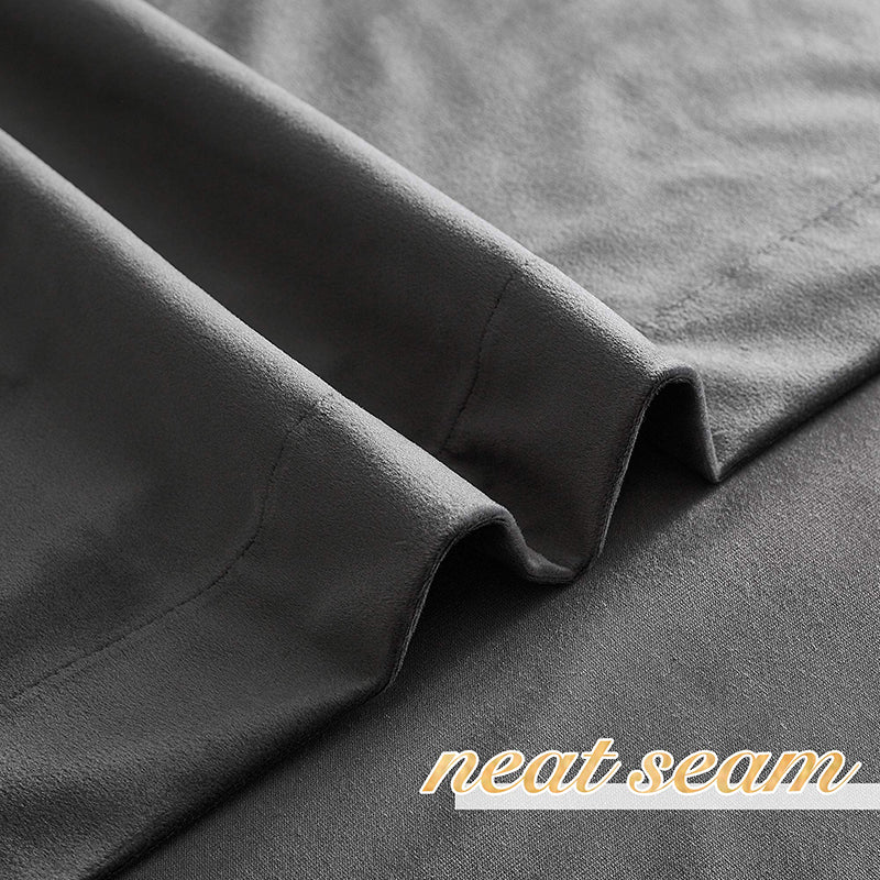 Close-up of dark grey velvet blackout curtain fabric, showing plush texture, elegant folds, and a neat seam.