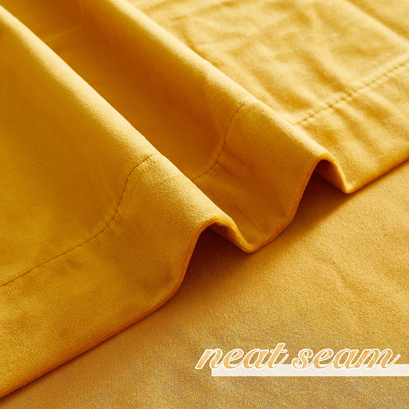 Close-up of a neat seam on a luxurious yellow velvet blackout curtain, showcasing the premium fabric texture for privacy.