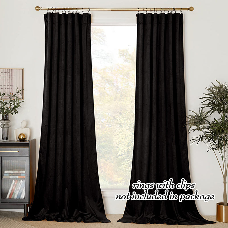 Set of 2 luxurious black velvet rod pocket blackout curtain panels, pooling on floor, ideal for living room & bedroom privacy.