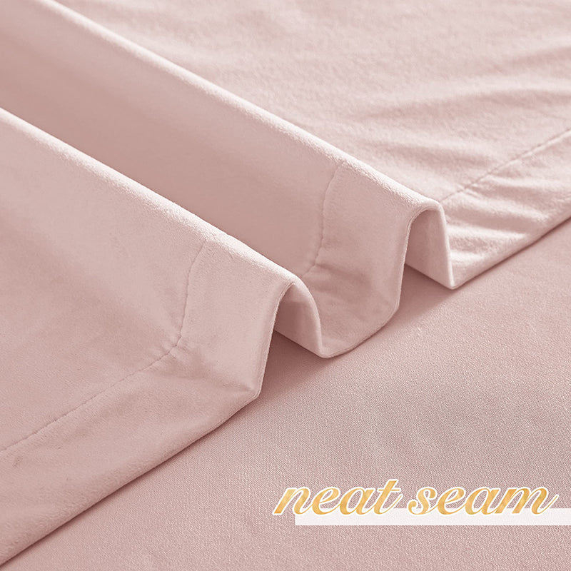 Close-up of plush pink velvet blackout curtain fabric, highlighting a neat, durable seam and luxurious texture.