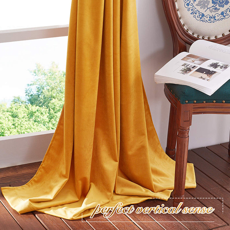 Luxurious golden velvet rod pocket blackout curtain panel for living room or bedroom, offering privacy, pooling on wood floor.