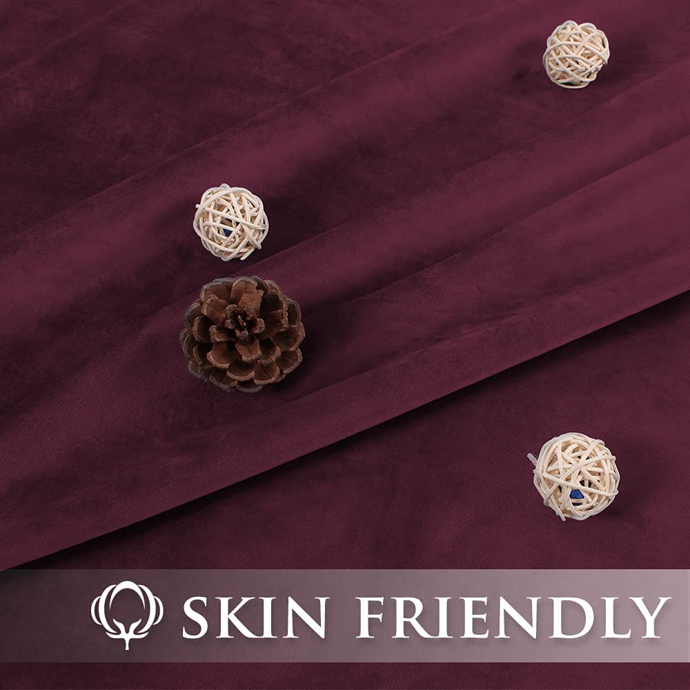 Plush burgundy velvet blackout curtain fabric detail, showcasing soft texture. Accented with a pinecone & wicker balls. Features 'SKIN FRIENDLY' text.