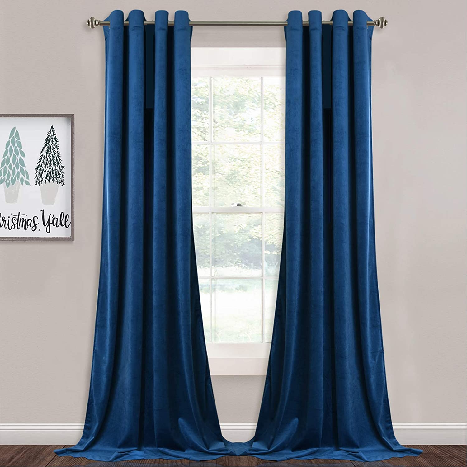 Two deep blue velvet blackout curtain panels with silver grommets, fully drawn over a window for living room or bedroom privacy.
