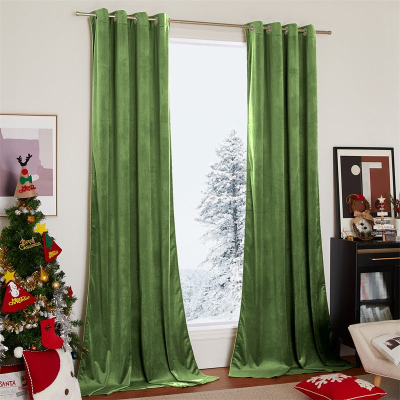 Two panels of green velvet blackout curtains with silver grommets elegantly frame a living room window, a snowy landscape visible outside.
