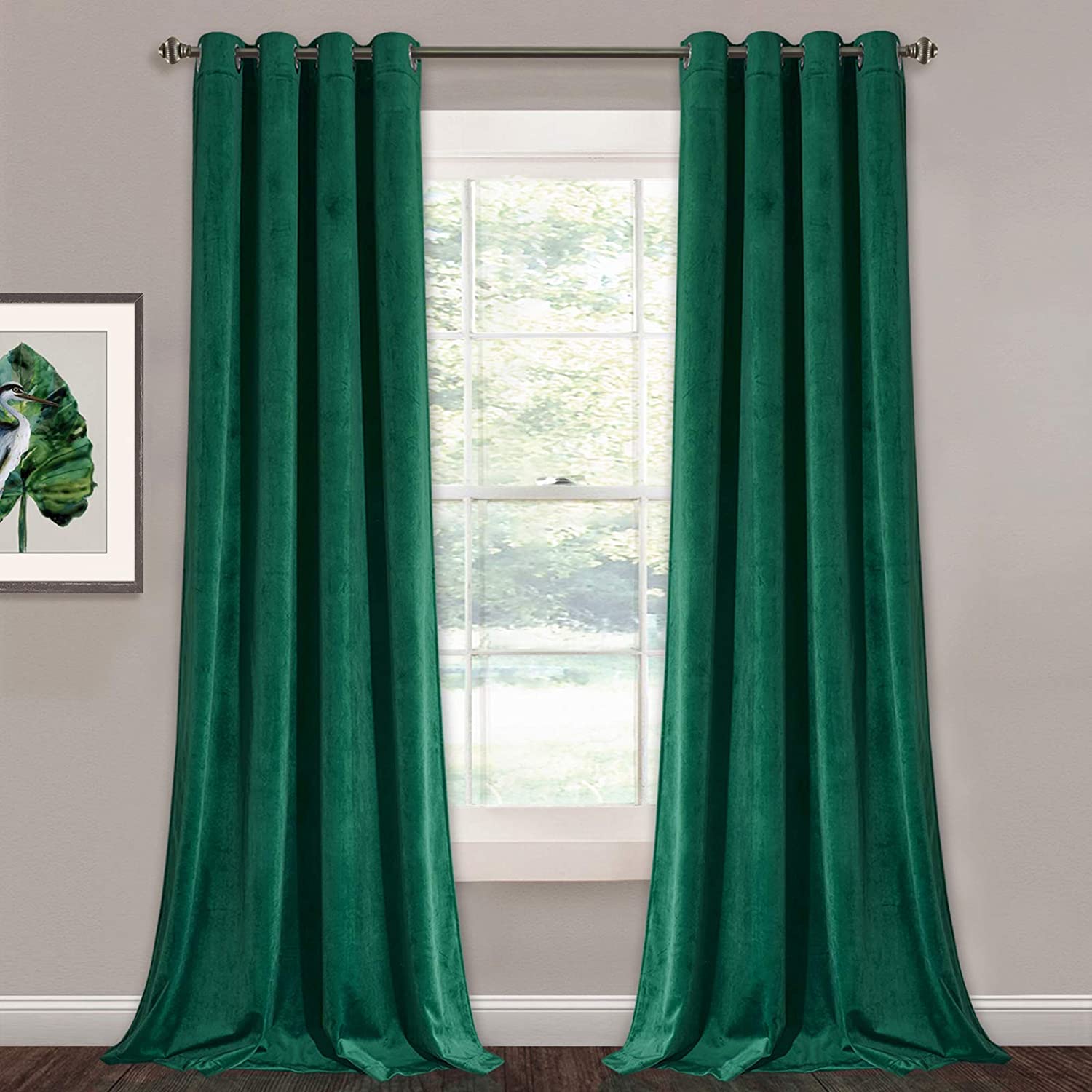 Two emerald green velvet blackout curtain panels with silver grommets, styled for a living room or bedroom window.