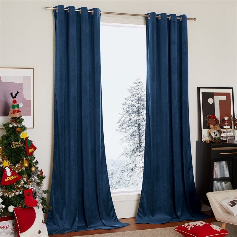 Navy velvet blackout curtains, 2 panels with silver grommets, adorning a living room window with a snowy outdoor scene.