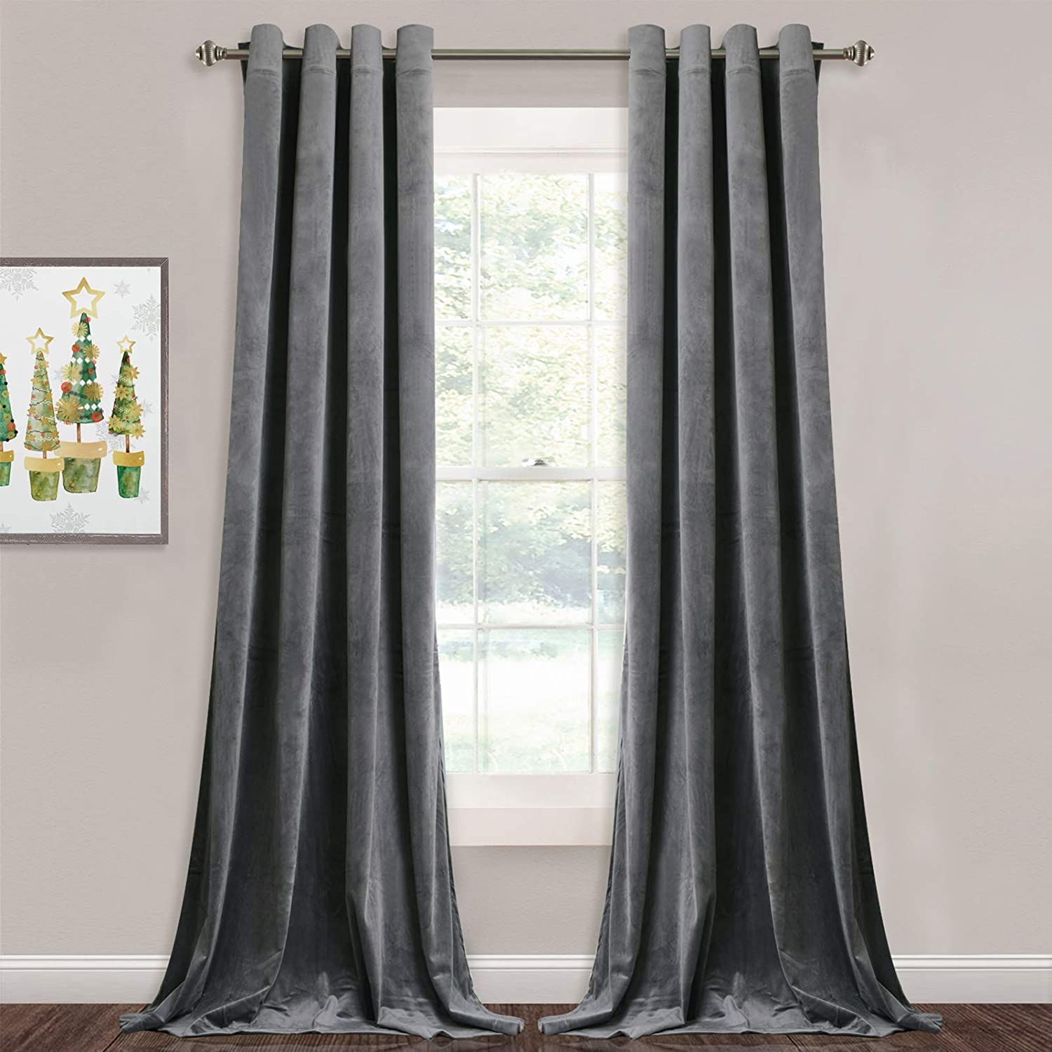 Two dark silver velvet blackout curtain panels with grommets hanging in a living room or bedroom window, pooling on a wood floor.