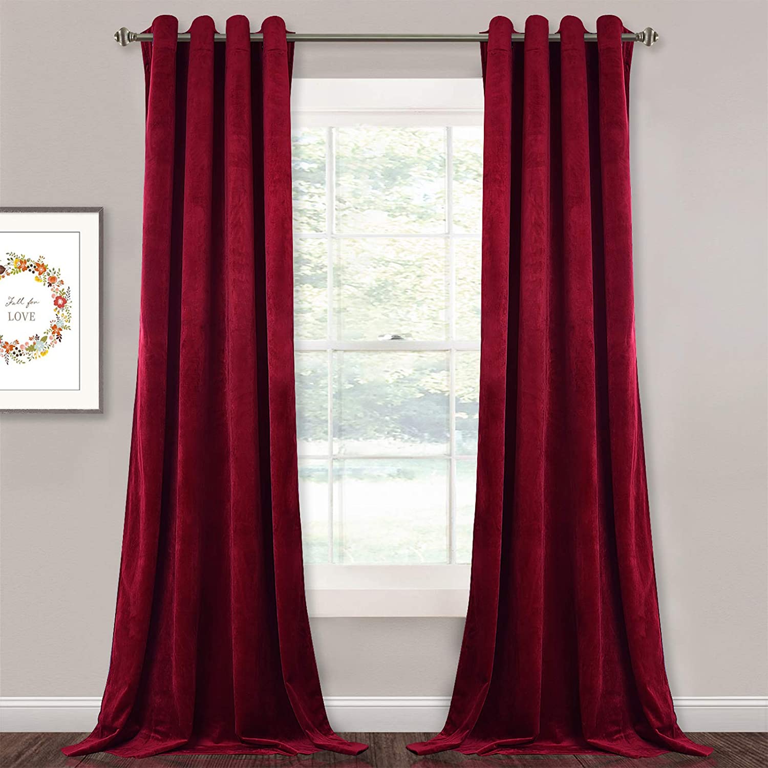 Rich red velvet blackout curtains with silver grommets, hanging as two panels for a bedroom or living room window.