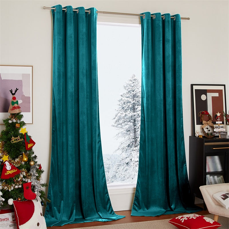 Two panels of elegant teal velvet blackout curtains with silver grommets, framing a snowy window in a cozy living room.