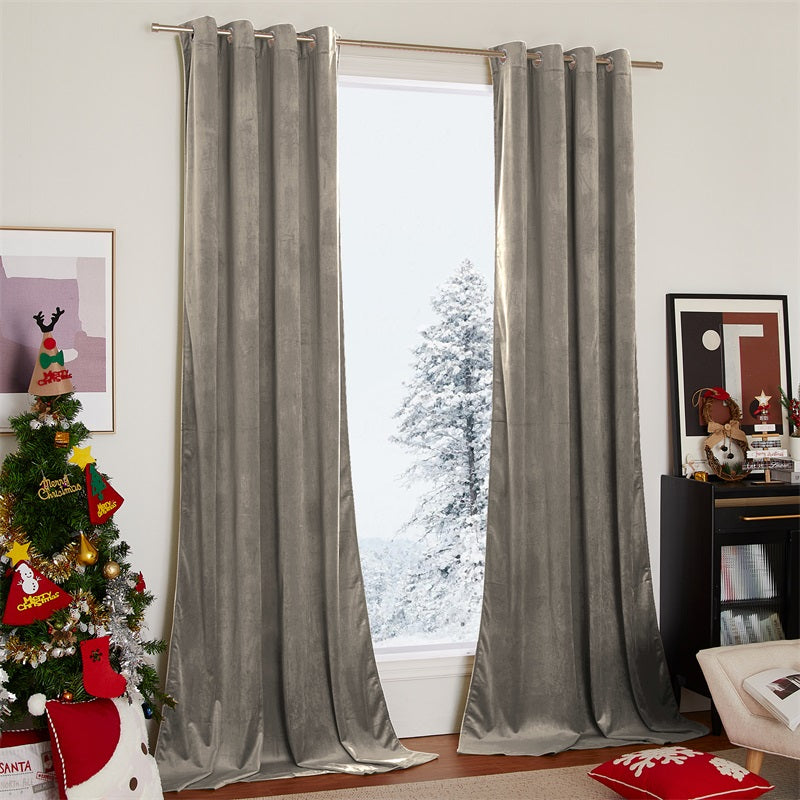Two silver grommet velvet blackout curtains in a living room, elegantly draped and partially open to a snowy window scene.