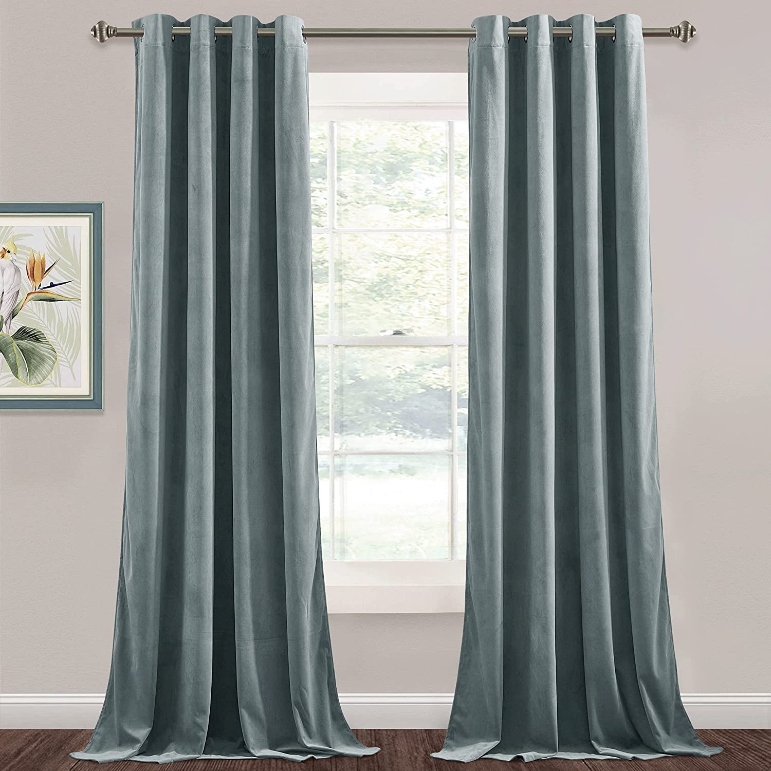 Two panels of plush light blue velvet blackout curtains with silver grommets, perfect for living room or bedroom windows.