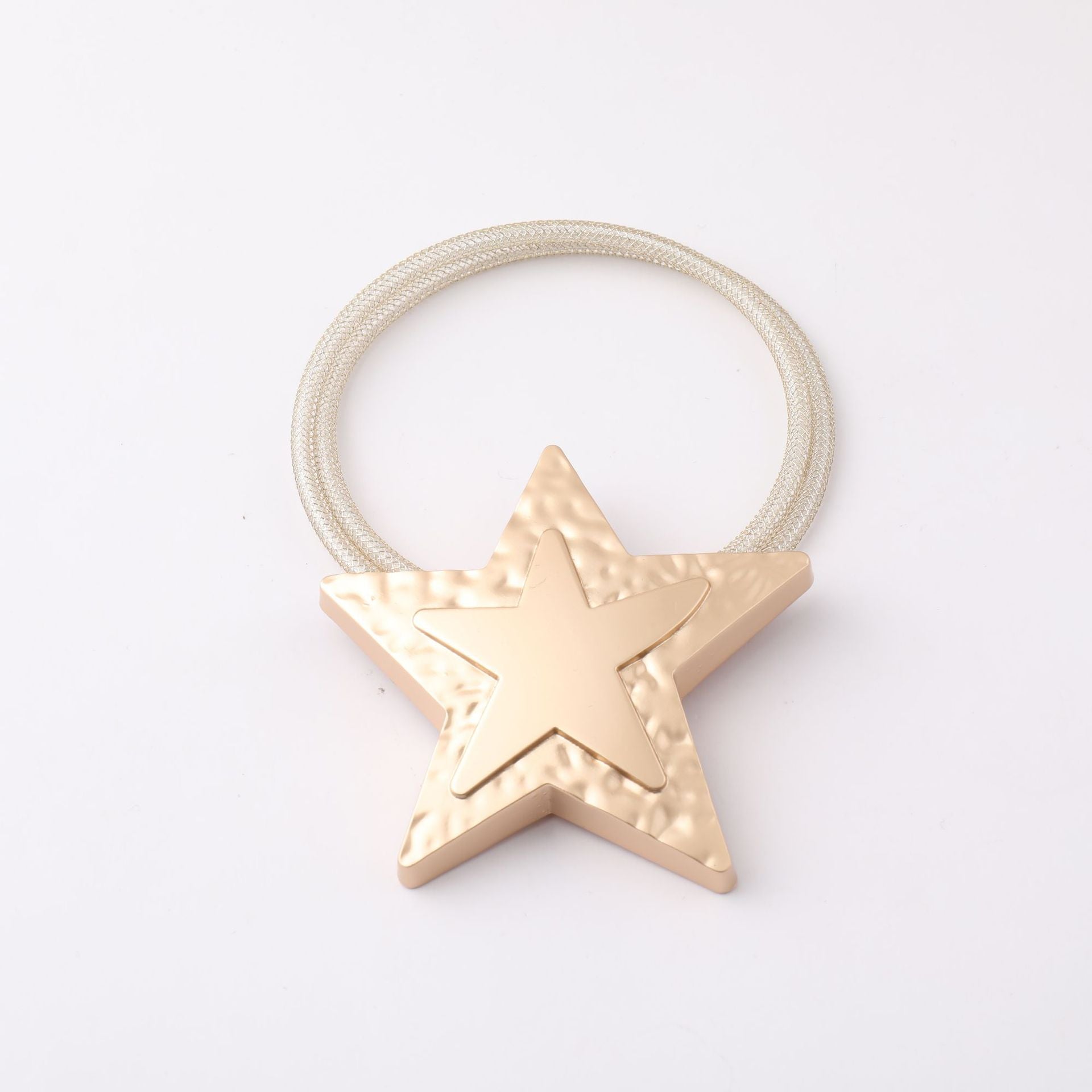 Gold star magnetic curtain tieback, a decorative buckle with embossed texture and a shimmering woven strap for curtains.