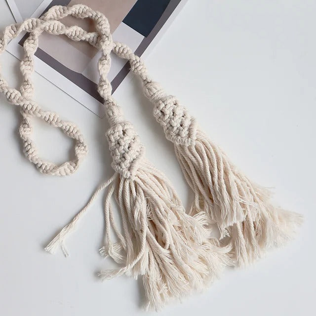 Hand-woven off-white rope curtain tieback with decorative tassels, an elegant accessory for window treatments.