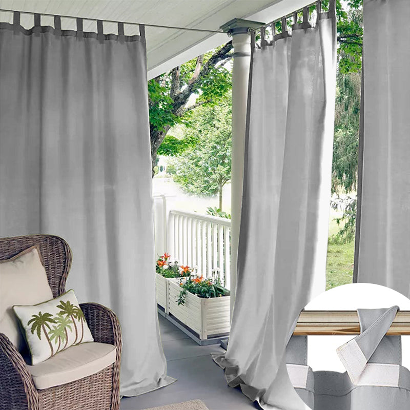 Grey waterproof outdoor curtains with easy-install Velcro tab tops on a patio for privacy & weather protection. Close-up detail.