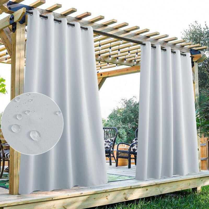 White waterproof grommet top patio outdoor curtains hanging from a pergola, with water droplets visible on the fabric.