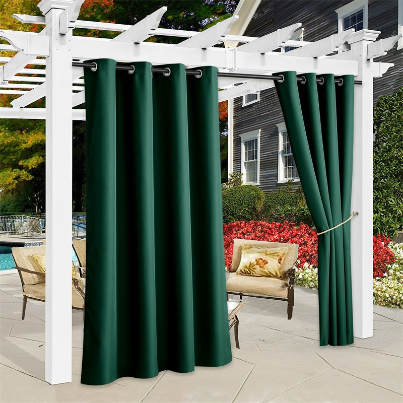 Dark green waterproof canvas outdoor curtains on white patio pergola, one panel tied back, providing privacy and shade for outdoor living.